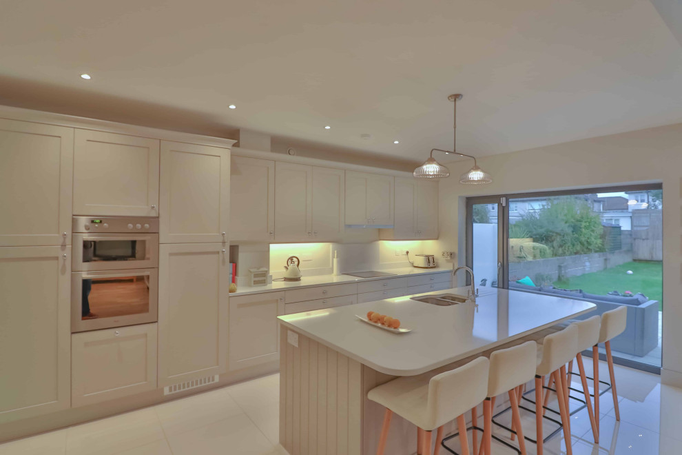 На фото: прямая кухня-гостиная среднего размера в стиле модернизм с фасадами в стиле шейкер, островом и сводчатым потолком