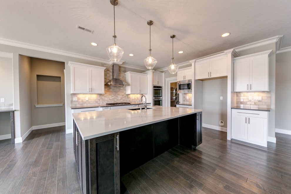 Open concept kitchen - large transitional l-shaped medium tone wood floor open concept kitchen idea in Seattle with an undermount sink, shaker cabinets, white cabinets, quartz countertops, white backsplash, porcelain backsplash, stainless steel appliances and an island
