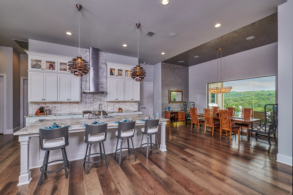 Inspiration for a mid-sized modern l-shaped medium tone wood floor and brown floor open concept kitchen remodel in Other with an undermount sink, shaker cabinets, white cabinets, white backsplash, subway tile backsplash, stainless steel appliances, an island and multicolored countertops