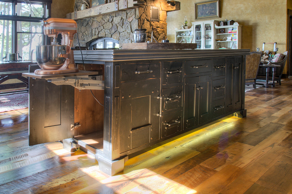 Photo of a large rustic l-shaped kitchen/diner in Minneapolis with flat-panel cabinets, black cabinets, zinc worktops, integrated appliances, medium hardwood flooring, an island and grey worktops.