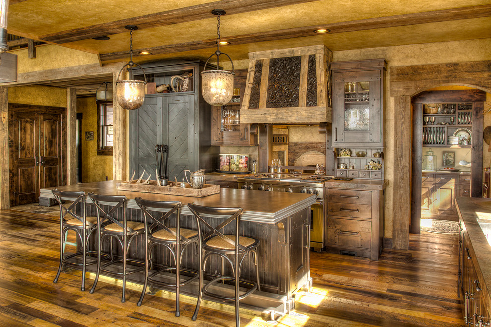 Exemple d'une grande cuisine américaine encastrable montagne en L et bois brun avec un évier encastré, un placard à porte plane, un plan de travail en zinc, un sol en bois brun, îlot et un plan de travail gris.