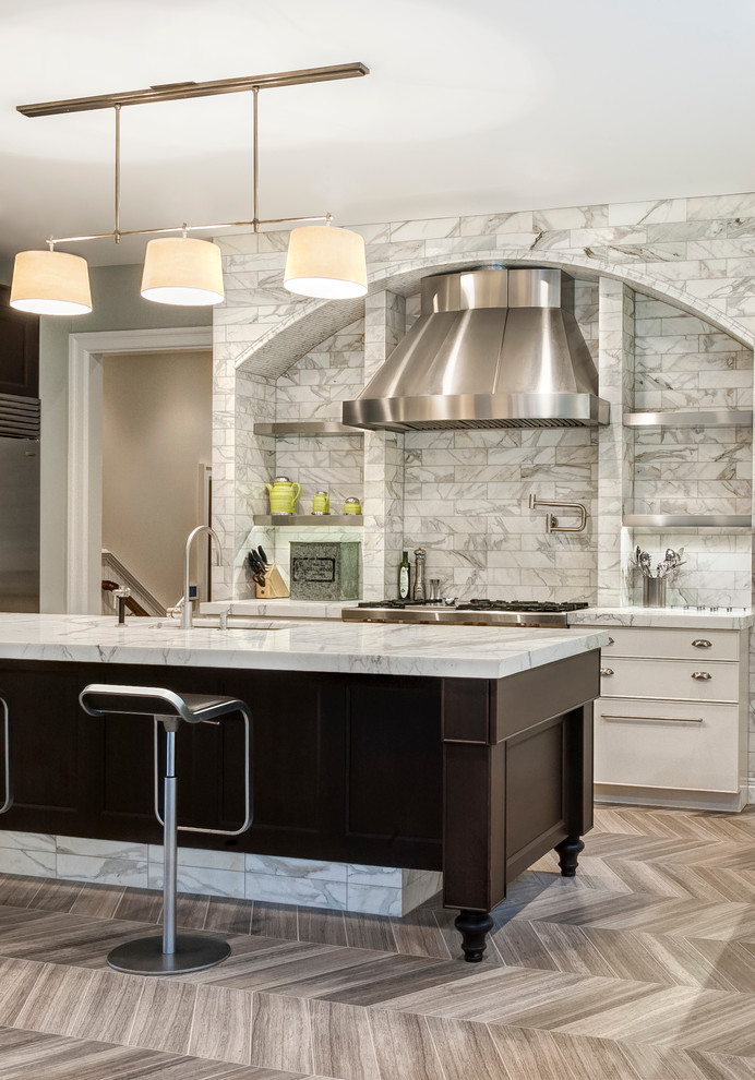 Modern inredning av ett stort kök, med en undermonterad diskho, luckor med infälld panel, skåp i mörkt trä, marmorbänkskiva, vitt stänkskydd, stänkskydd i stenkakel, rostfria vitvaror, kalkstensgolv och en köksö