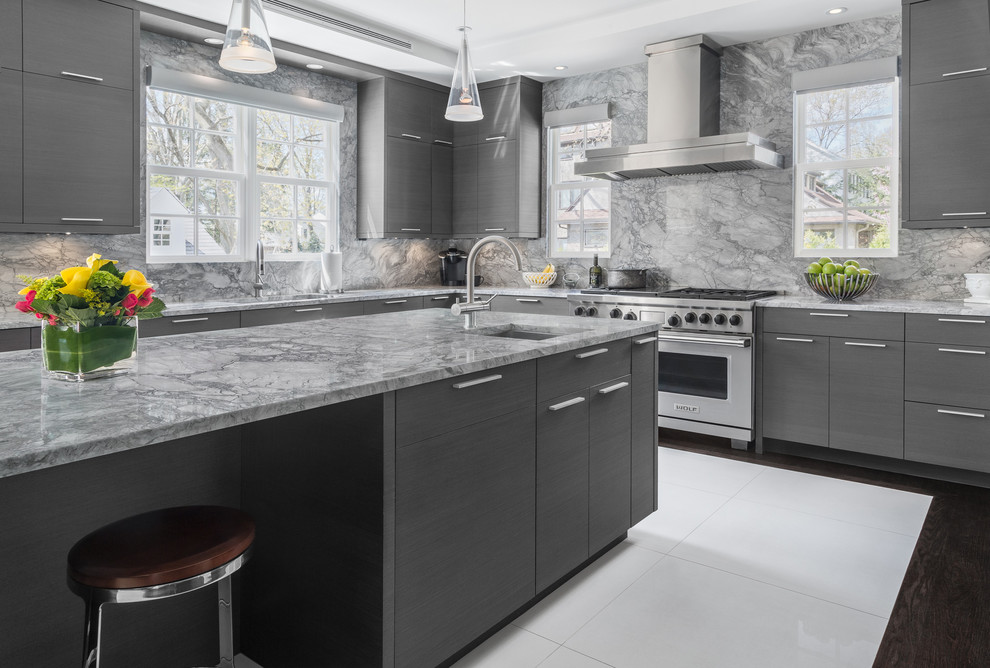 Foto på ett stort funkis l-kök, med marmorbänkskiva, grått stänkskydd, stänkskydd i sten, klinkergolv i porslin, en köksö, vitt golv, en undermonterad diskho, släta luckor, grå skåp och rostfria vitvaror