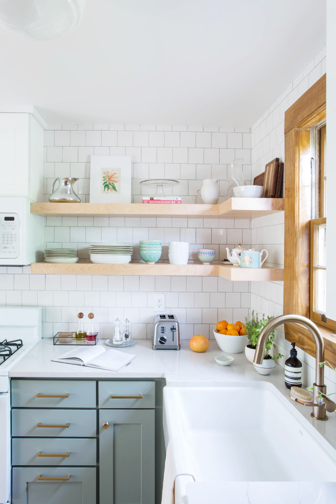 Example of a small transitional l-shaped dark wood floor and brown floor eat-in kitchen design in Other with a farmhouse sink, recessed-panel cabinets, gray cabinets, quartz countertops, white backsplash, subway tile backsplash, white appliances and a peninsula