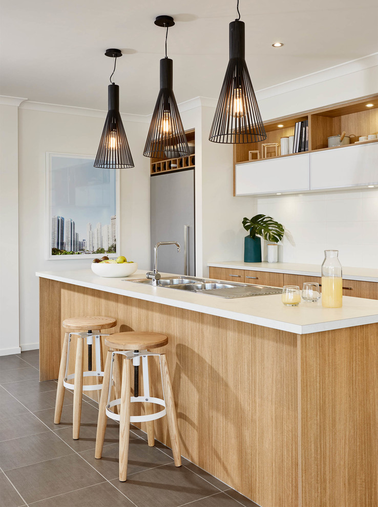 Inspiration for a contemporary kitchen in Melbourne with a double-bowl sink, flat-panel cabinets, light wood cabinets, stainless steel appliances and an island.