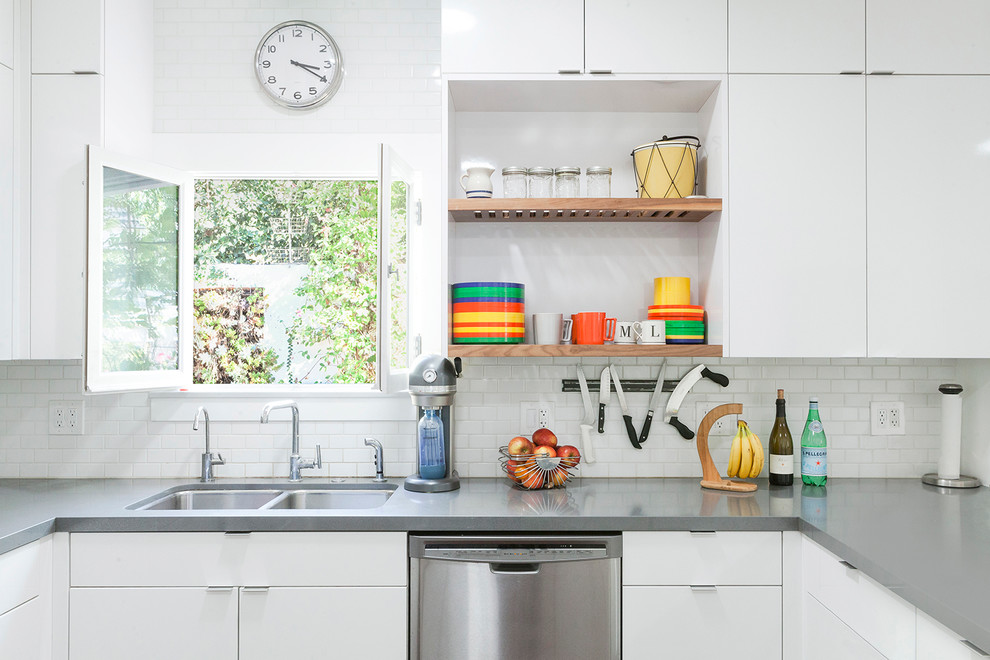 Photo of a bohemian kitchen in Los Angeles with flat-panel cabinets, white cabinets, white splashback and ceramic splashback.