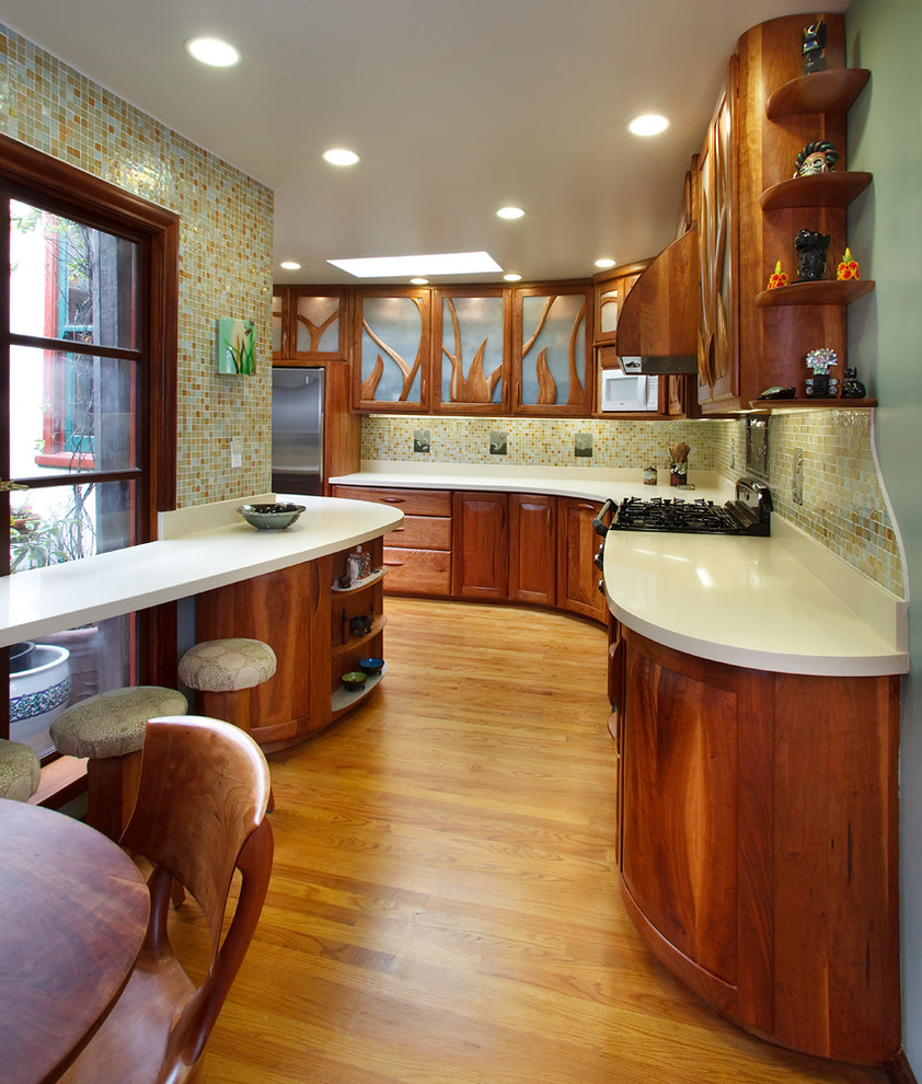 Exempel på ett litet eklektiskt kök, med luckor med upphöjd panel, skåp i mellenmörkt trä, bänkskiva i kvarts, vitt stänkskydd, stänkskydd i glaskakel, mellanmörkt trägolv, en dubbel diskho, färgglada vitvaror och brunt golv