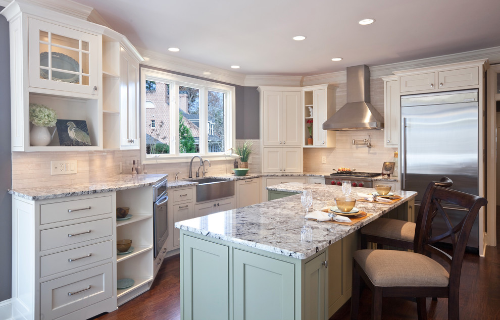 Example of a trendy l-shaped kitchen design in Atlanta with stainless steel appliances, a farmhouse sink, granite countertops, beaded inset cabinets, white cabinets, beige backsplash and stone tile backsplash