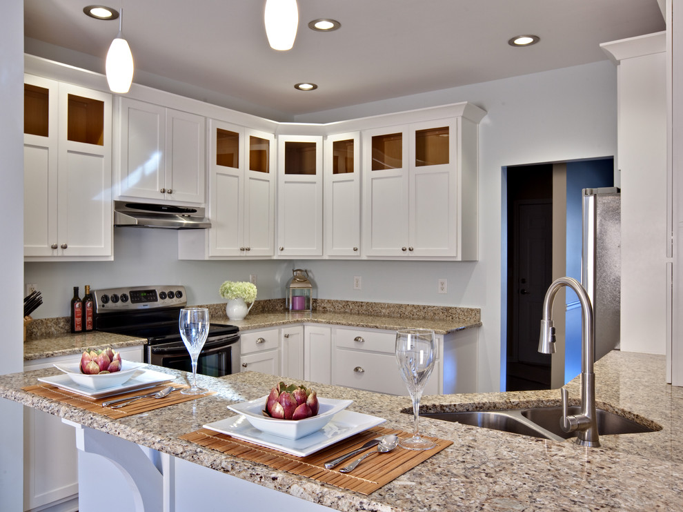 Bild på ett mellanstort funkis beige beige kök, med rostfria vitvaror, granitbänkskiva, en dubbel diskho, vita skåp, skåp i shakerstil, mellanmörkt trägolv, en halv köksö och brunt golv