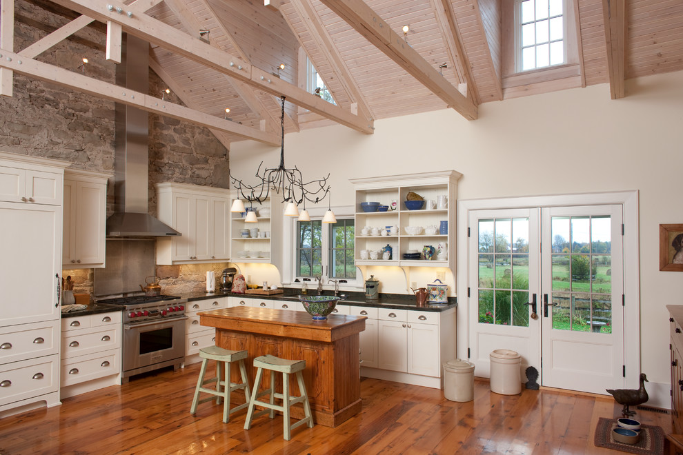 Foto di una cucina country con ante in stile shaker, ante beige, paraspruzzi multicolore e pavimento in legno massello medio