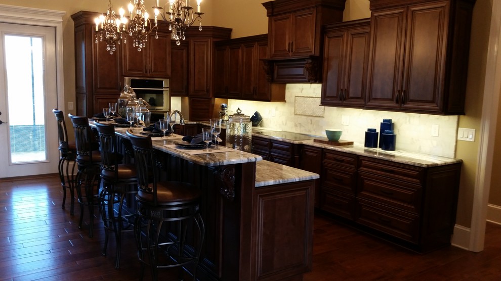 Foto di una cucina classica di medie dimensioni con ante con bugna sagomata, ante in legno bruno, top in marmo, paraspruzzi grigio, paraspruzzi in marmo, elettrodomestici in acciaio inossidabile e parquet scuro