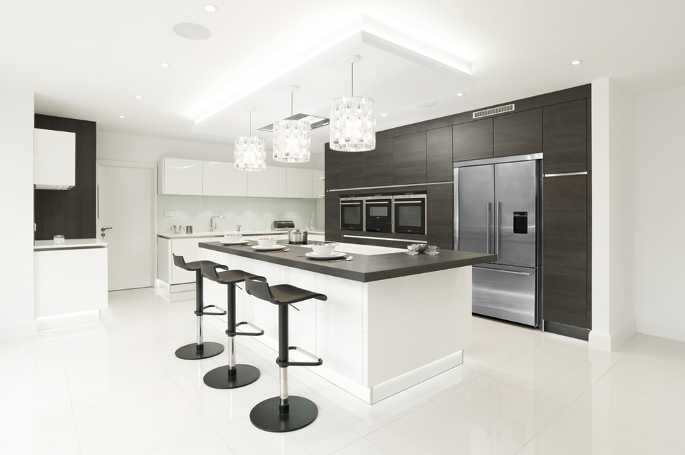 Inspiration for a contemporary l-shaped kitchen/diner in London with a double-bowl sink, flat-panel cabinets, dark wood cabinets, white splashback, glass sheet splashback, stainless steel appliances, porcelain flooring and an island.