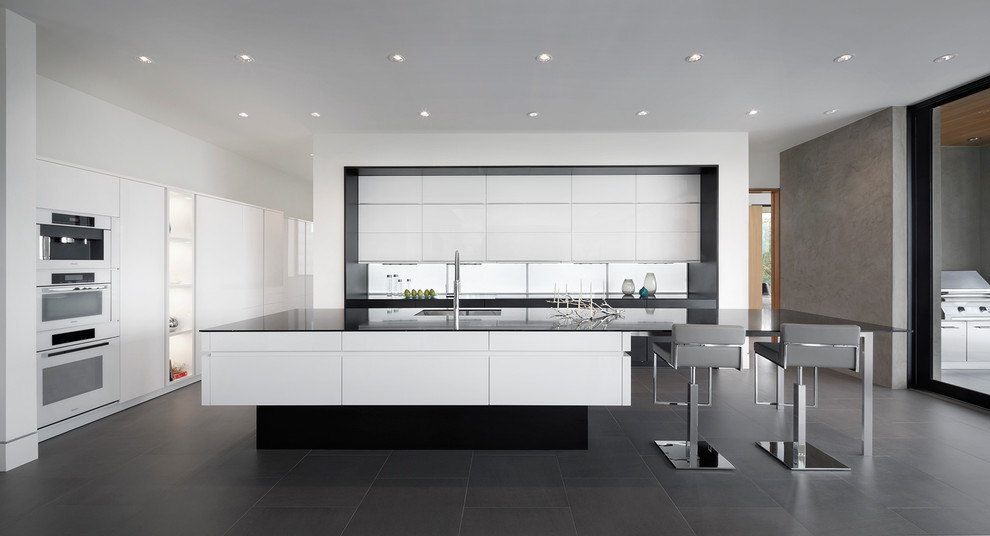 This is an example of a contemporary kitchen in Austin with white appliances, a submerged sink, flat-panel cabinets, white cabinets and an island.