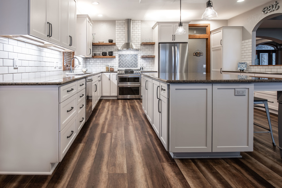 Exempel på ett stort lantligt brun brunt kök, med en undermonterad diskho, luckor med infälld panel, grå skåp, granitbänkskiva, vitt stänkskydd, stänkskydd i keramik, rostfria vitvaror, vinylgolv, en köksö och brunt golv