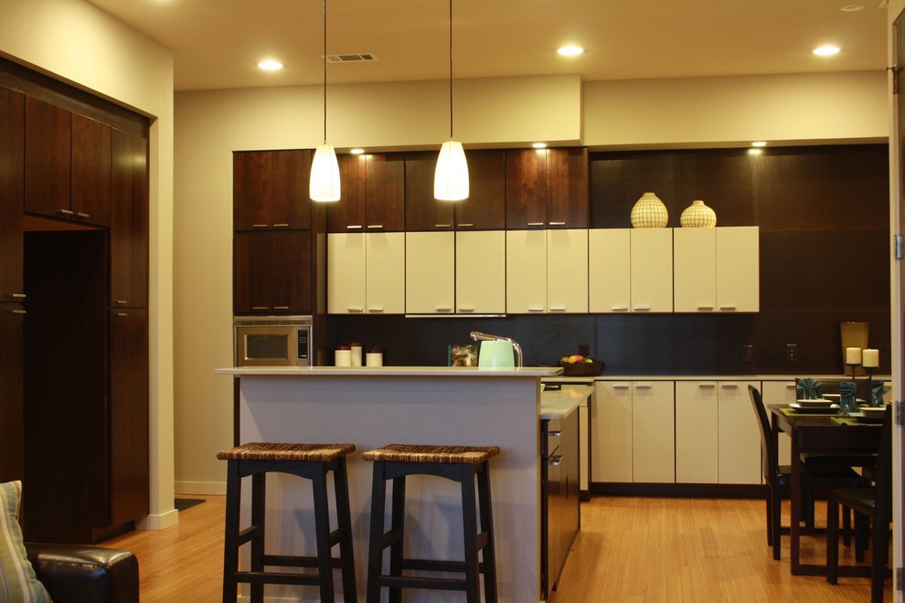 Bild på ett funkis kök och matrum, med släta luckor, vita skåp och brunt stänkskydd