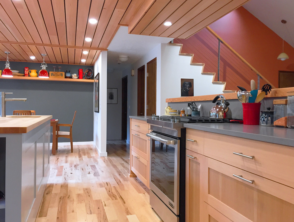 Exempel på ett mellanstort modernt kök, med en undermonterad diskho, släta luckor, skåp i ljust trä, bänkskiva i kvarts, grått stänkskydd, rostfria vitvaror, ljust trägolv och en köksö