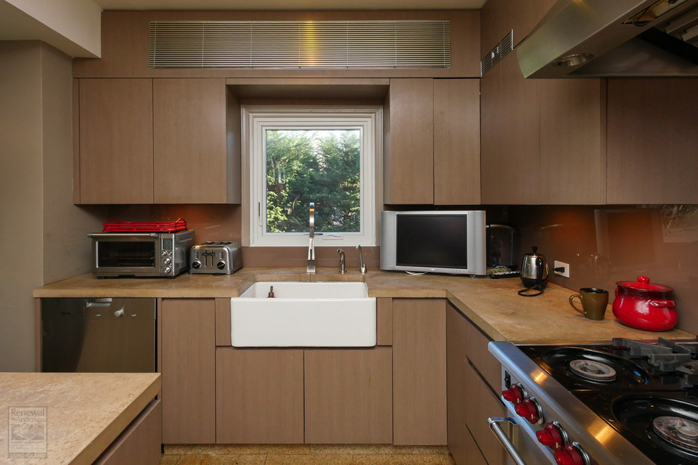 Cette image montre une cuisine en L et bois brun fermée et de taille moyenne avec un évier de ferme, une crédence marron, un électroménager en acier inoxydable, un sol en liège, îlot, un sol beige et un plan de travail beige.