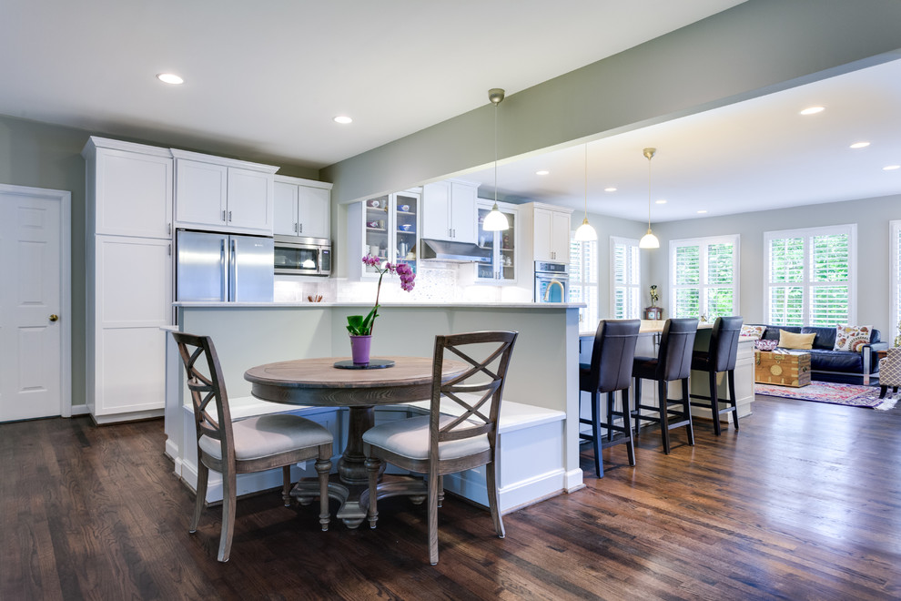 Example of a classic open concept kitchen design in Other with shaker cabinets, white cabinets, white backsplash and stainless steel appliances