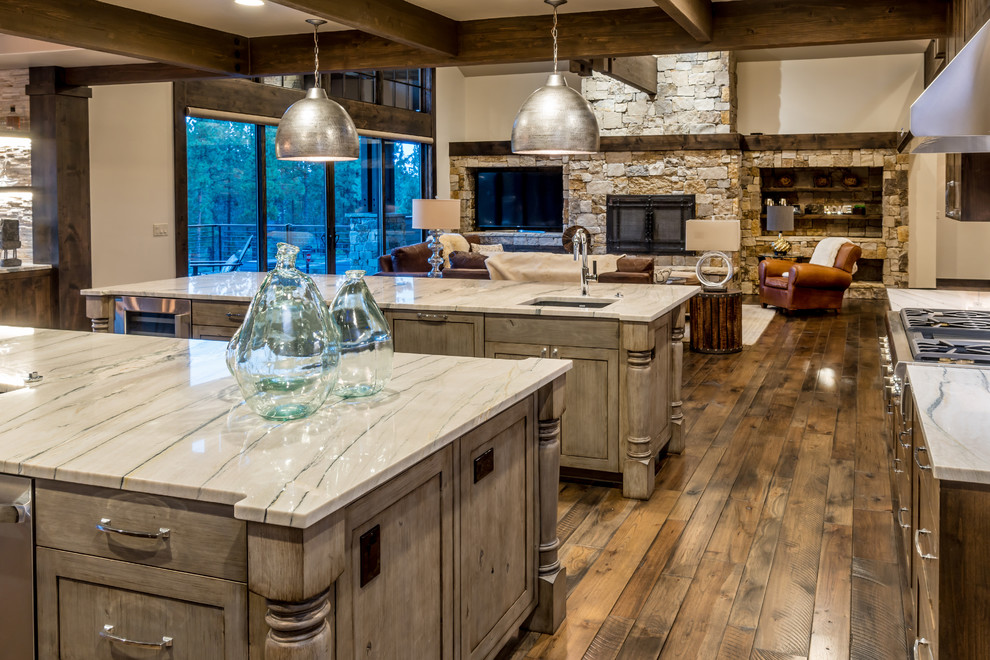 Design ideas for an expansive rustic u-shaped open plan kitchen in Other with a submerged sink, recessed-panel cabinets, distressed cabinets, quartz worktops, grey splashback, porcelain splashback, stainless steel appliances, medium hardwood flooring and multiple islands.