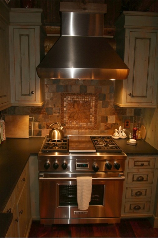 Exempel på ett mellanstort rustikt kök, med en rustik diskho, luckor med infälld panel, skåp i slitet trä, granitbänkskiva, brunt stänkskydd, stänkskydd i stenkakel, integrerade vitvaror och mörkt trägolv