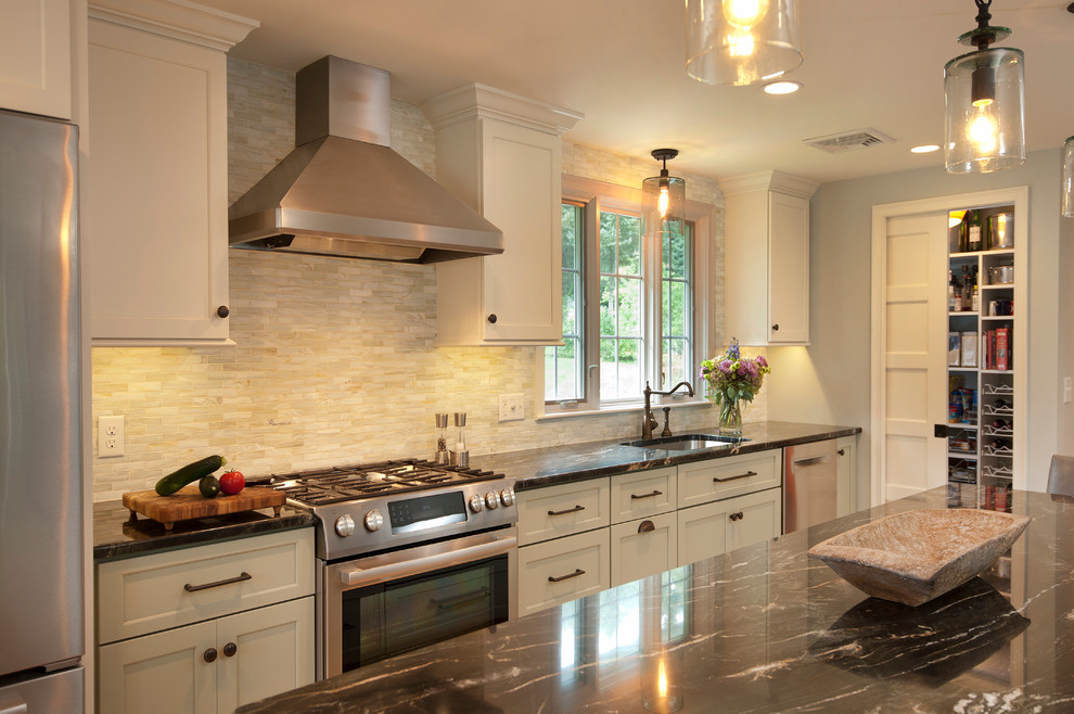 Inredning av ett modernt kök, med en undermonterad diskho, skåp i shakerstil, vita skåp, granitbänkskiva, flerfärgad stänkskydd, stänkskydd i tunnelbanekakel, rostfria vitvaror, ljust trägolv och en köksö