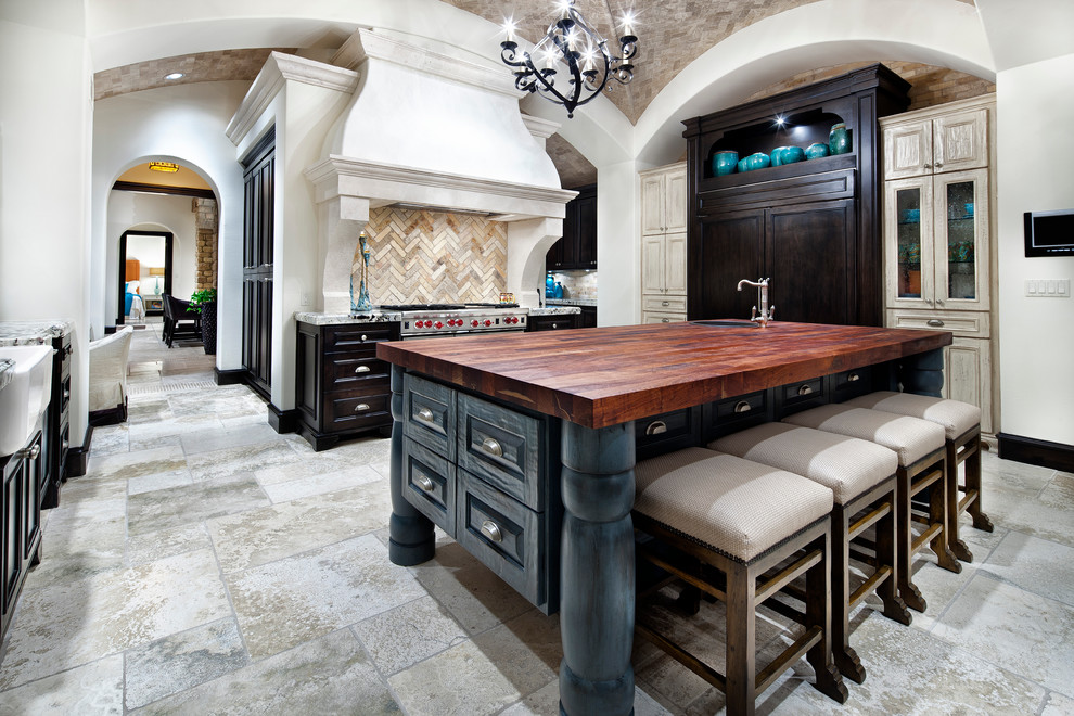 Tuscan kitchen photo in Houston with wood countertops, blue cabinets, beige backsplash and paneled appliances