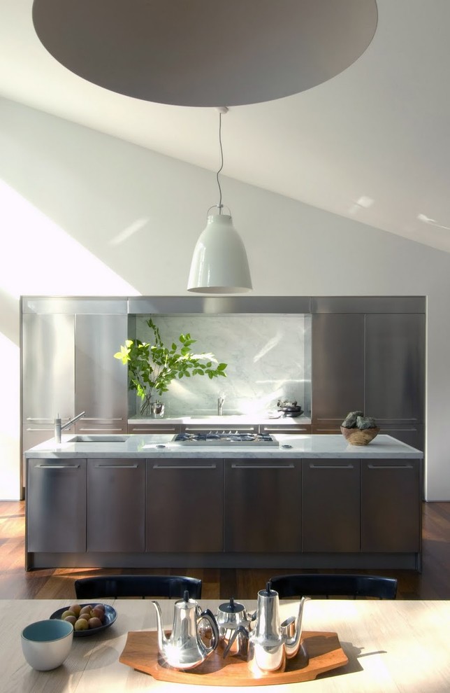 Esempio di una cucina parallela minimal con top in marmo, elettrodomestici in acciaio inossidabile, ante lisce, ante in acciaio inossidabile, paraspruzzi bianco e paraspruzzi in lastra di pietra