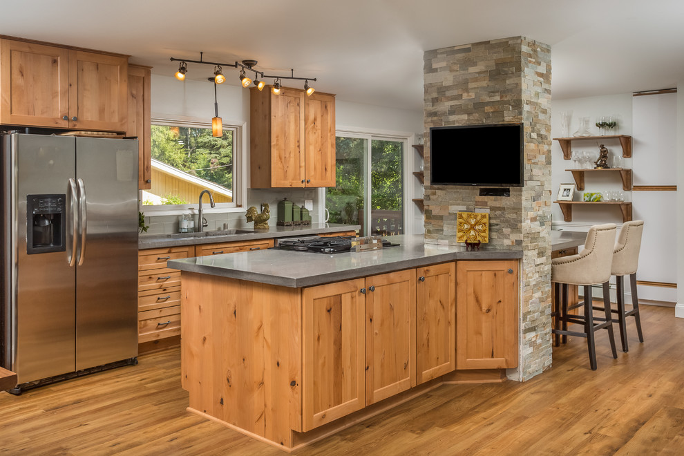 Medium sized rustic galley open plan kitchen in Other with a submerged sink, shaker cabinets, light wood cabinets, concrete worktops, grey splashback, glass tiled splashback, stainless steel appliances, vinyl flooring and an island.