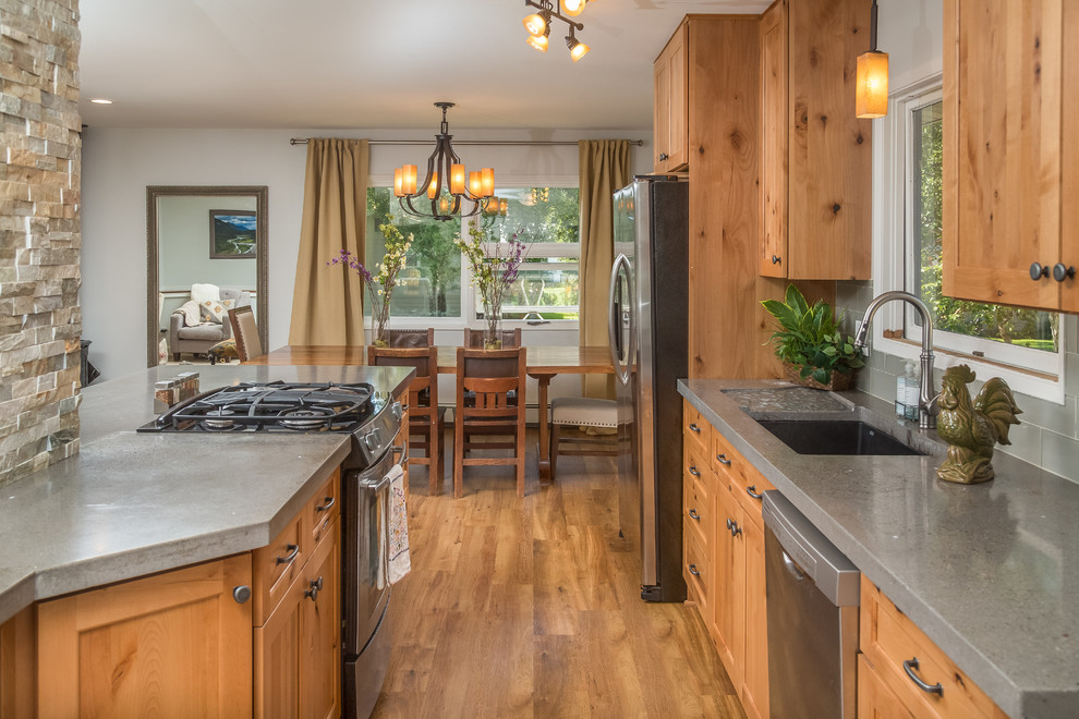 Inspiration for a mid-sized rustic galley vinyl floor open concept kitchen remodel in Other with an undermount sink, shaker cabinets, light wood cabinets, concrete countertops, gray backsplash, glass tile backsplash, stainless steel appliances and an island