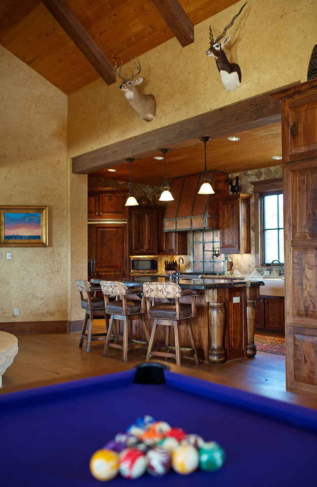 Inspiration för ett mellanstort rustikt linjärt kök med öppen planlösning, med en rustik diskho, luckor med upphöjd panel, skåp i mellenmörkt trä, marmorbänkskiva, stänkskydd i stenkakel, svarta vitvaror, ljust trägolv, en köksö, brunt stänkskydd och brunt golv