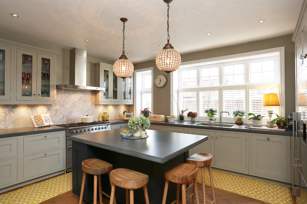 Kitchen - mid-sized transitional u-shaped kitchen idea in London with an undermount sink, shaker cabinets and an island