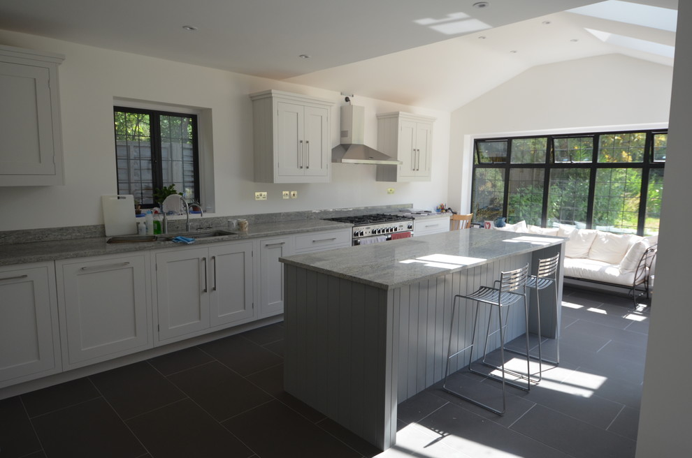 Inspiration for a large farmhouse u-shaped open plan kitchen in Surrey with an integrated sink, shaker cabinets, white cabinets, marble worktops, grey splashback, stainless steel appliances and an island.