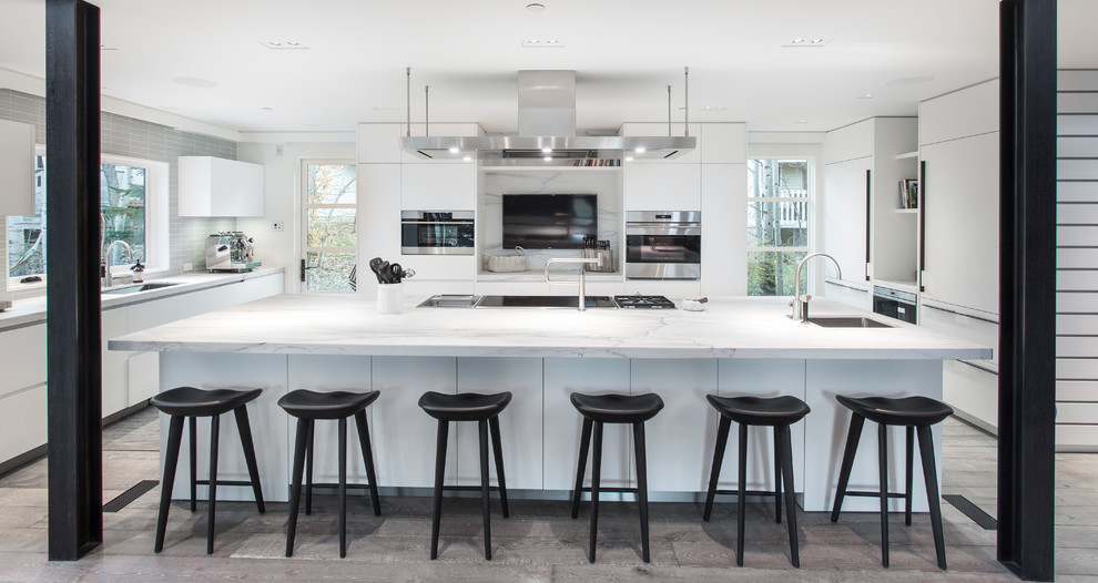 Inspiration for a large contemporary u-shaped gray floor open concept kitchen remodel in Salt Lake City with an undermount sink, flat-panel cabinets, white cabinets, marble countertops, gray backsplash, an island, gray countertops, marble backsplash and stainless steel appliances