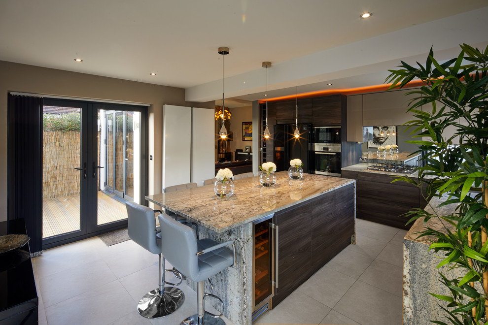 Design ideas for a large contemporary open plan kitchen in Cheshire with flat-panel cabinets, dark wood cabinets, granite worktops, mirror splashback, black appliances, porcelain flooring, an island and beige floors.
