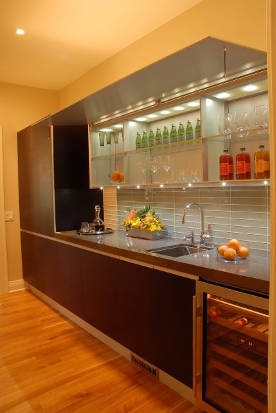 Exempel på ett mellanstort modernt kök, med en undermonterad diskho, släta luckor, skåp i mörkt trä, bänkskiva i kvarts, grått stänkskydd, stänkskydd i glaskakel, rostfria vitvaror och ljust trägolv