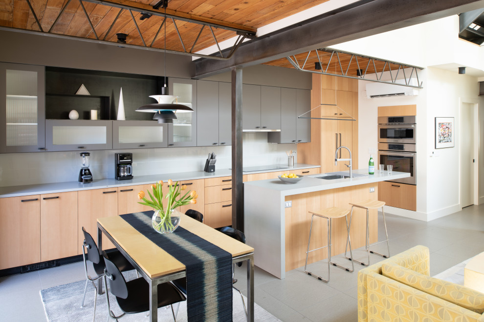 Cette photo montre une cuisine américaine industrielle de taille moyenne avec un sol en carrelage de porcelaine et un sol gris.