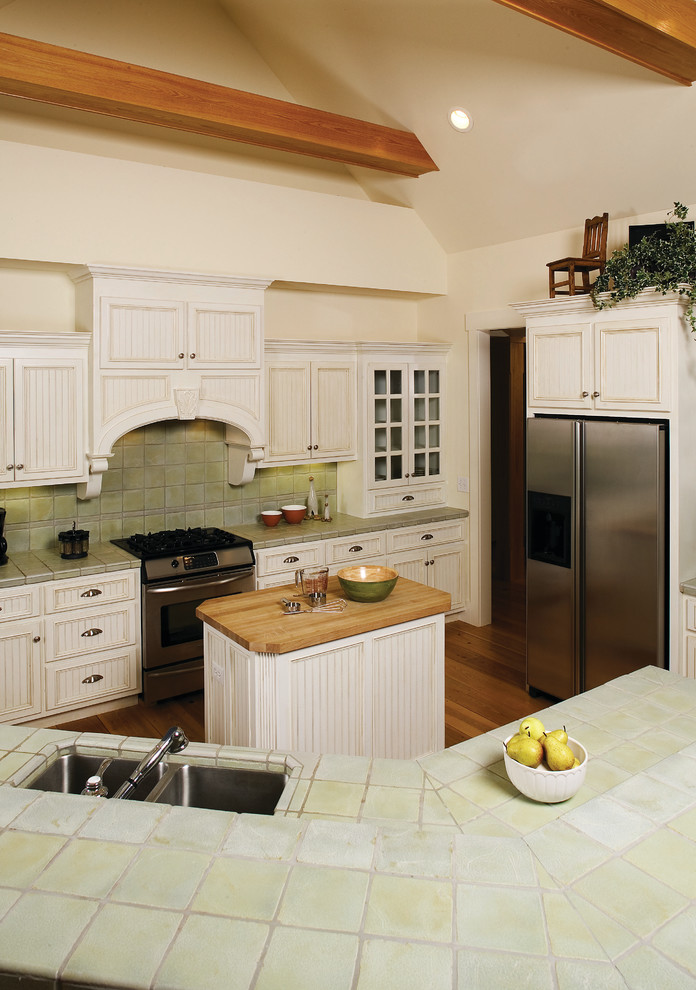 シャーロットにある広いトラディショナルスタイルのおしゃれなキッチン (アンダーカウンターシンク、インセット扉のキャビネット、白いキャビネット、タイルカウンター、緑のキッチンパネル、シルバーの調理設備、無垢フローリング) の写真