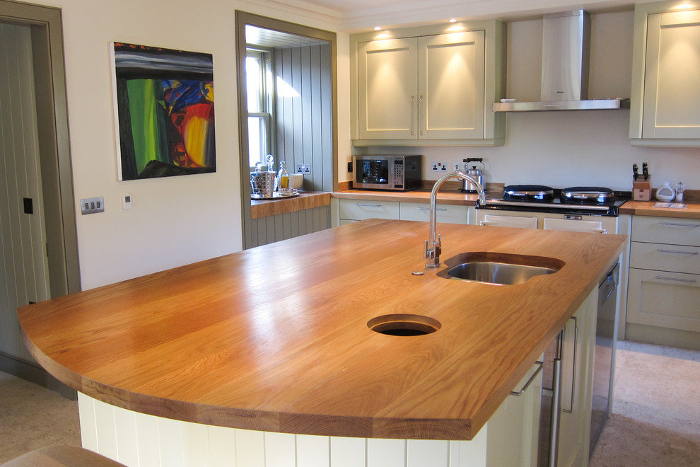 This is an example of a medium sized classic single-wall enclosed kitchen in Other with a double-bowl sink, recessed-panel cabinets, green cabinets, wood worktops, coloured appliances and an island.