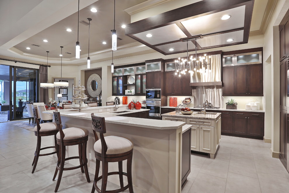 Design ideas for a large contemporary l-shaped open plan kitchen in Tampa with a submerged sink, flat-panel cabinets, dark wood cabinets, composite countertops, beige splashback, glass tiled splashback, integrated appliances, travertine flooring and an island.