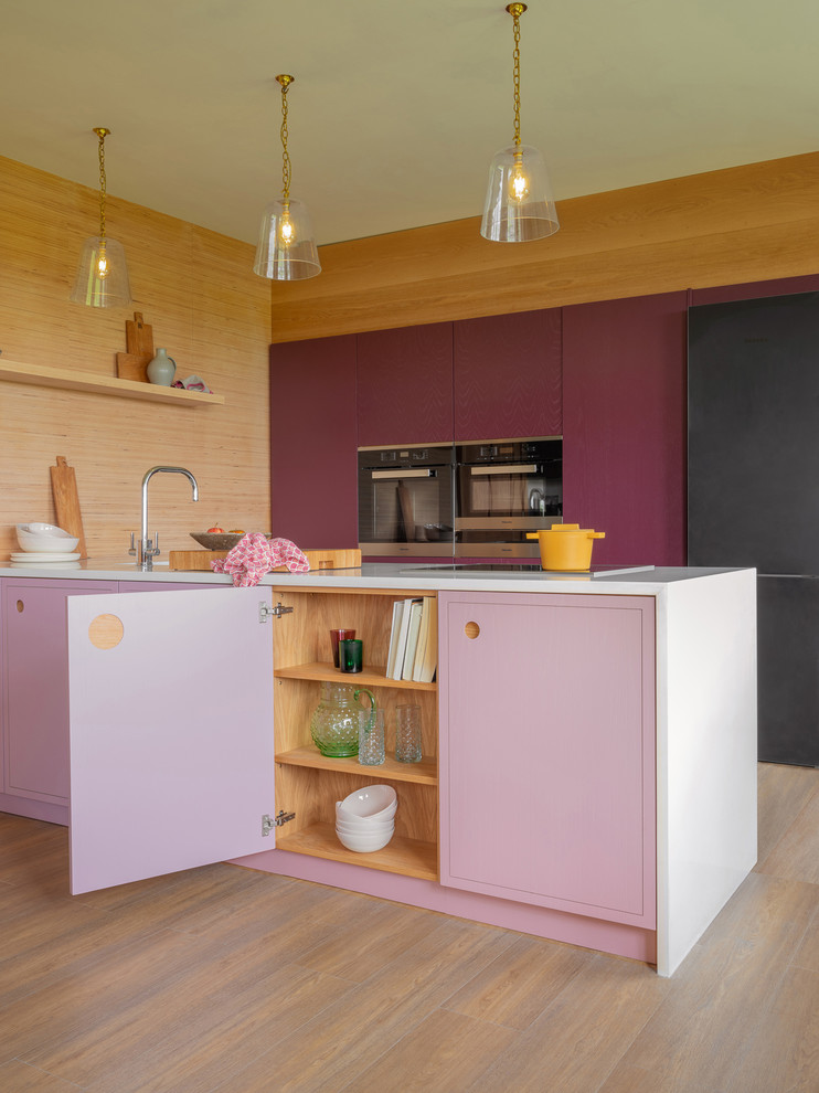 This is an example of a small contemporary kitchen in Other with a single-bowl sink, flat-panel cabinets, purple cabinets, quartz worktops, stainless steel appliances, medium hardwood flooring, an island, brown floors and white worktops.