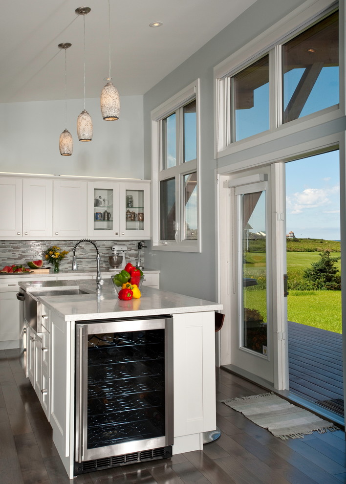 На фото: угловая кухня в стиле модернизм с с полувстраиваемой мойкой (с передним бортиком), фасадами в стиле шейкер, белыми фасадами и островом