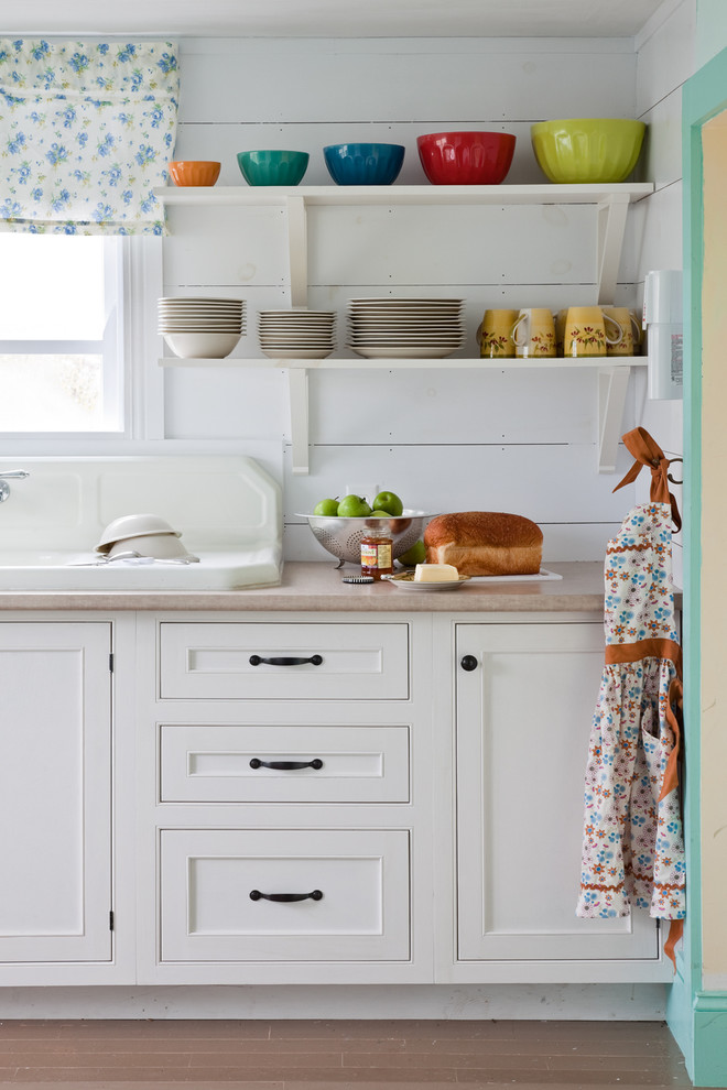 Inspiration pour une cuisine marine avec un évier posé, un placard à porte affleurante et des portes de placard blanches.