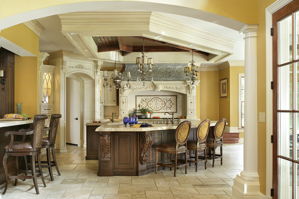 Inspiration for a large timeless l-shaped travertine floor eat-in kitchen remodel in New York with a farmhouse sink, beaded inset cabinets, white cabinets, limestone countertops, beige backsplash, stone tile backsplash, paneled appliances and two islands