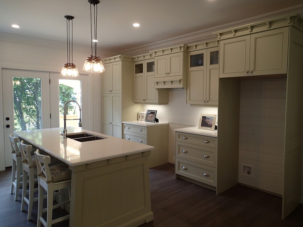 Example of a mid-sized arts and crafts single-wall medium tone wood floor open concept kitchen design in Toronto with a double-bowl sink, shaker cabinets, green cabinets, quartzite countertops, white backsplash and an island