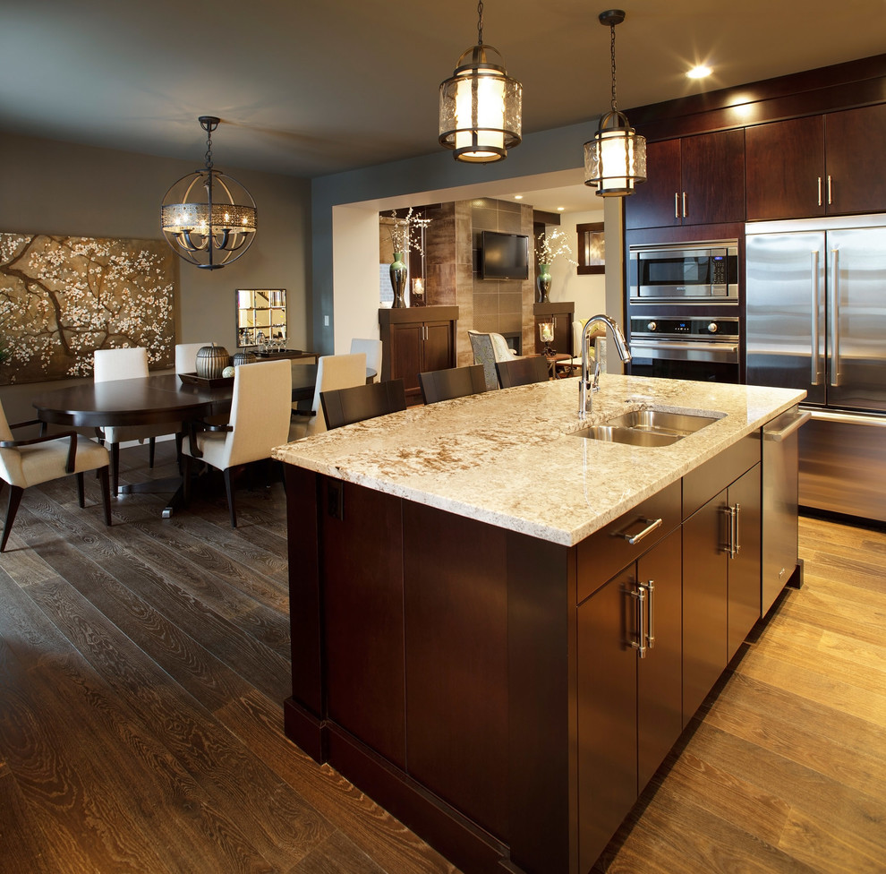 Eat-in kitchen - traditional medium tone wood floor eat-in kitchen idea in Calgary with a double-bowl sink, flat-panel cabinets, dark wood cabinets, stainless steel appliances, granite countertops and an island