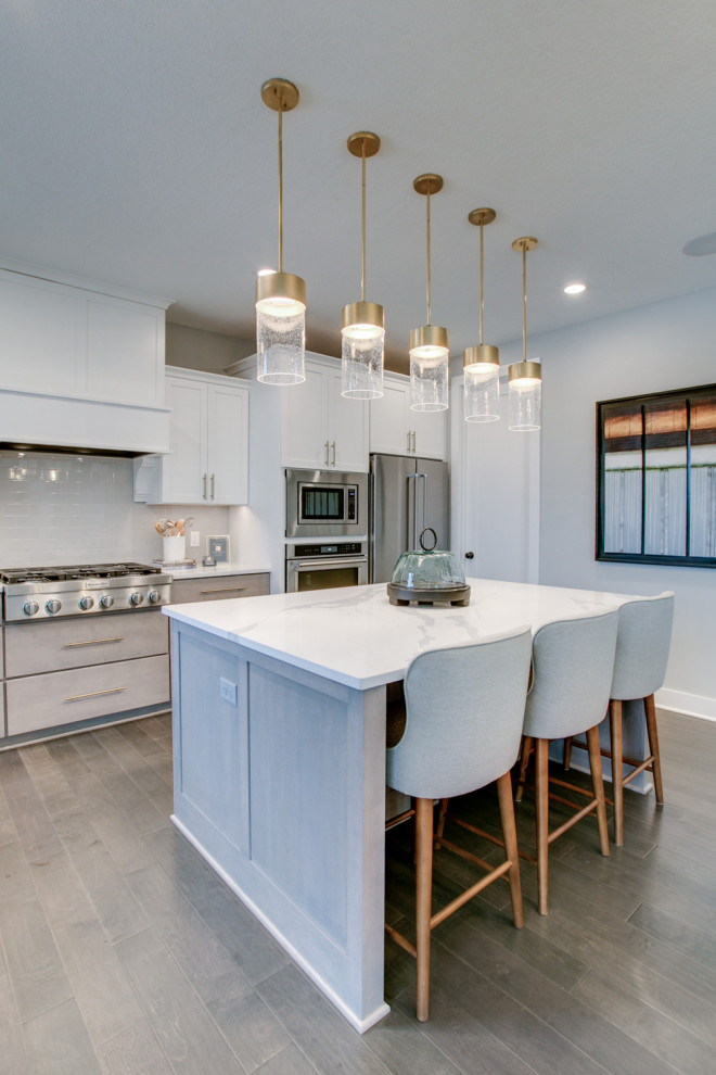 Immagine di una cucina classica di medie dimensioni con ante lisce, ante beige, paraspruzzi beige, elettrodomestici in acciaio inossidabile, pavimento grigio e top bianco
