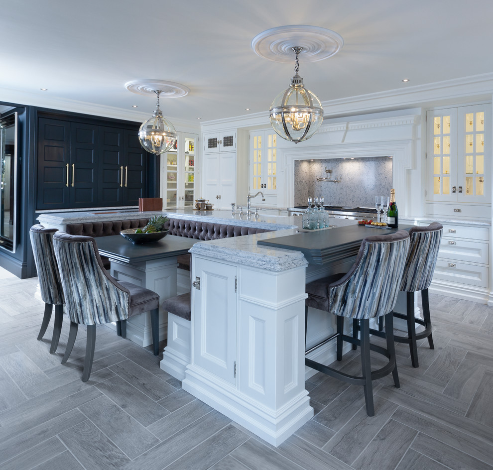 Exempel på ett klassiskt grå grått kök, med luckor med infälld panel, vita skåp, grått stänkskydd, rostfria vitvaror, ljust trägolv, en köksö och grått golv