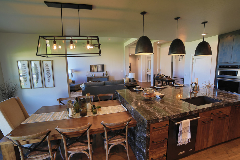Example of a mid-sized trendy l-shaped light wood floor and brown floor open concept kitchen design in Salt Lake City with glass-front cabinets, white cabinets, granite countertops, gray backsplash, ceramic backsplash, stainless steel appliances, an island and black countertops