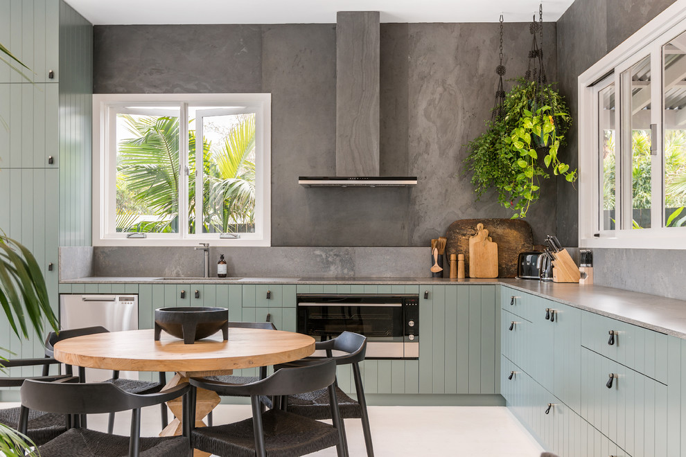 Medium sized nautical l-shaped kitchen/diner in Other with green cabinets, grey splashback, white floors, brown worktops, a submerged sink and stainless steel appliances.