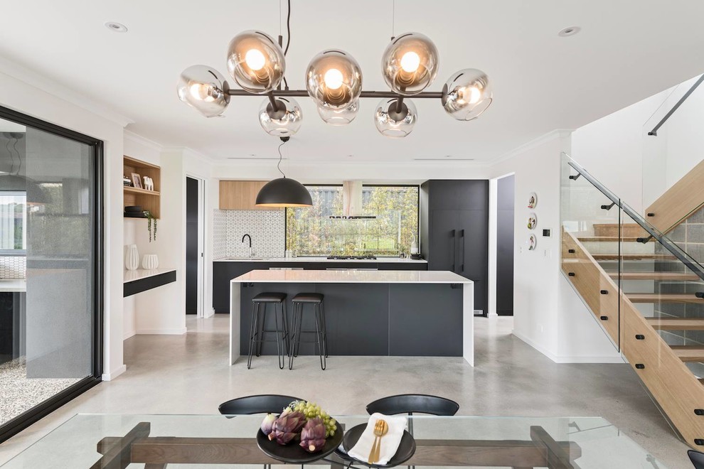 Idéer för ett stort modernt vit kök, med en köksö, en enkel diskho, svarta skåp, bänkskiva i kvarts, glaspanel som stänkskydd, rostfria vitvaror, betonggolv och grått golv